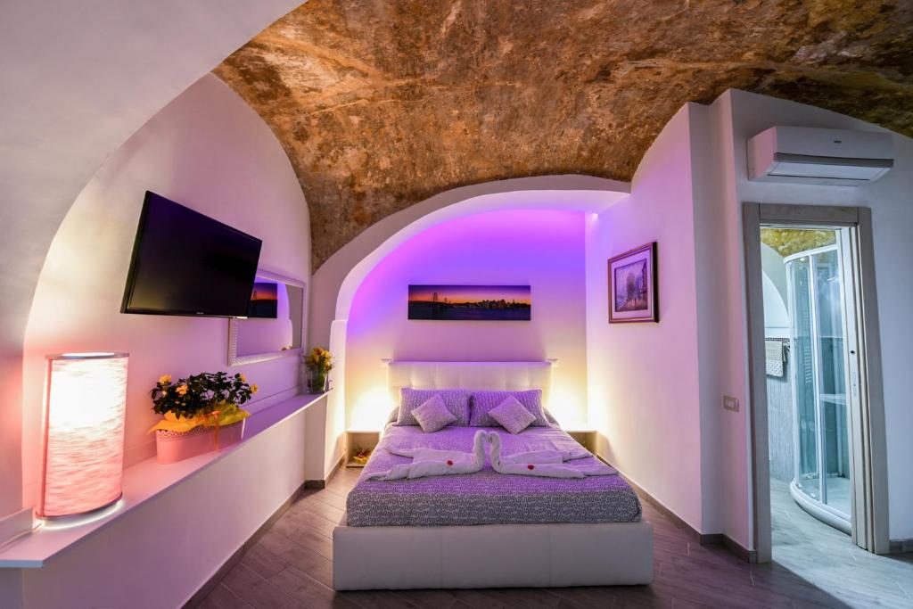 sypialnia z fioletowymi ścianami i łóżkiem w pokoju w obiekcie Petros Room Camere w mieście Salerno