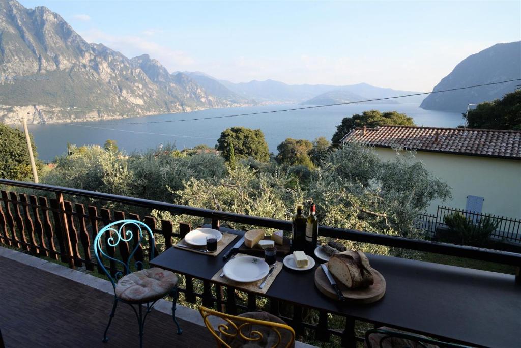 a table on a balcony with a view of the water at IseoLakeRental - Villa Retrò in Riva di Solto