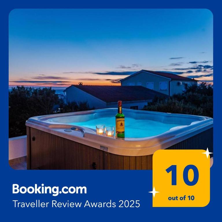 a hot tub with a bottle of wine in it at LUXURY MANDRE HOUSE in Mandre