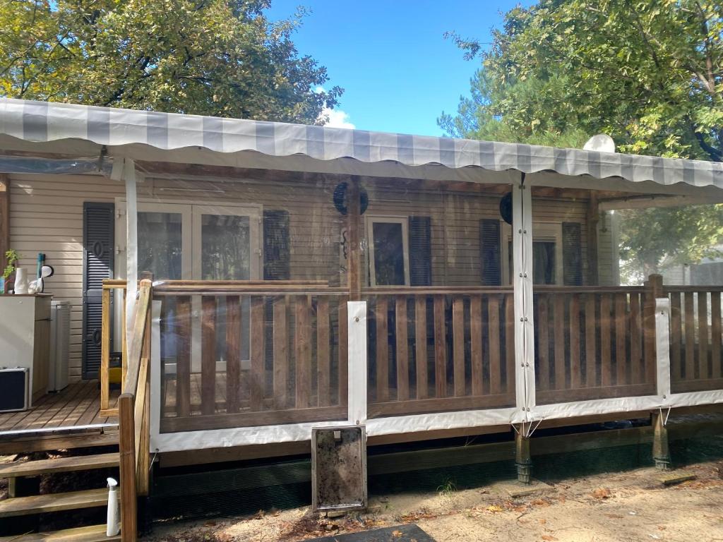 une terrasse couverte avec un toit sur une maison dans l'établissement MH 007 ELITE 3 chambres dont suite parentale et 2 salles de bain sur magnifique parcelle dans camping 4 étoiles, à Saint-Julien-en-Born