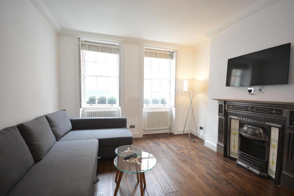 a living room with a couch and a fireplace at Bloomsbury Residences in London