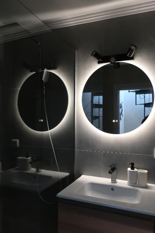 two mirrors above a white sink in a bathroom at Home Santa Clara in Albufeira