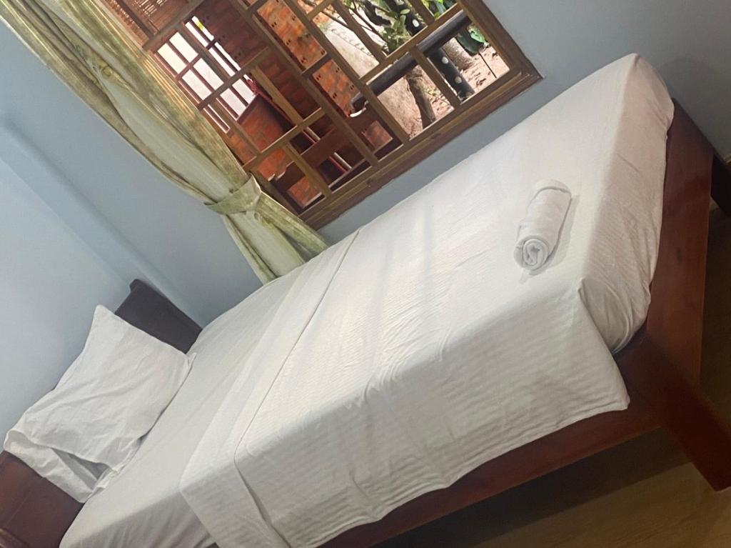 a bed in a bedroom with a window at Thành Khôi Bungalow in Phú Quốc