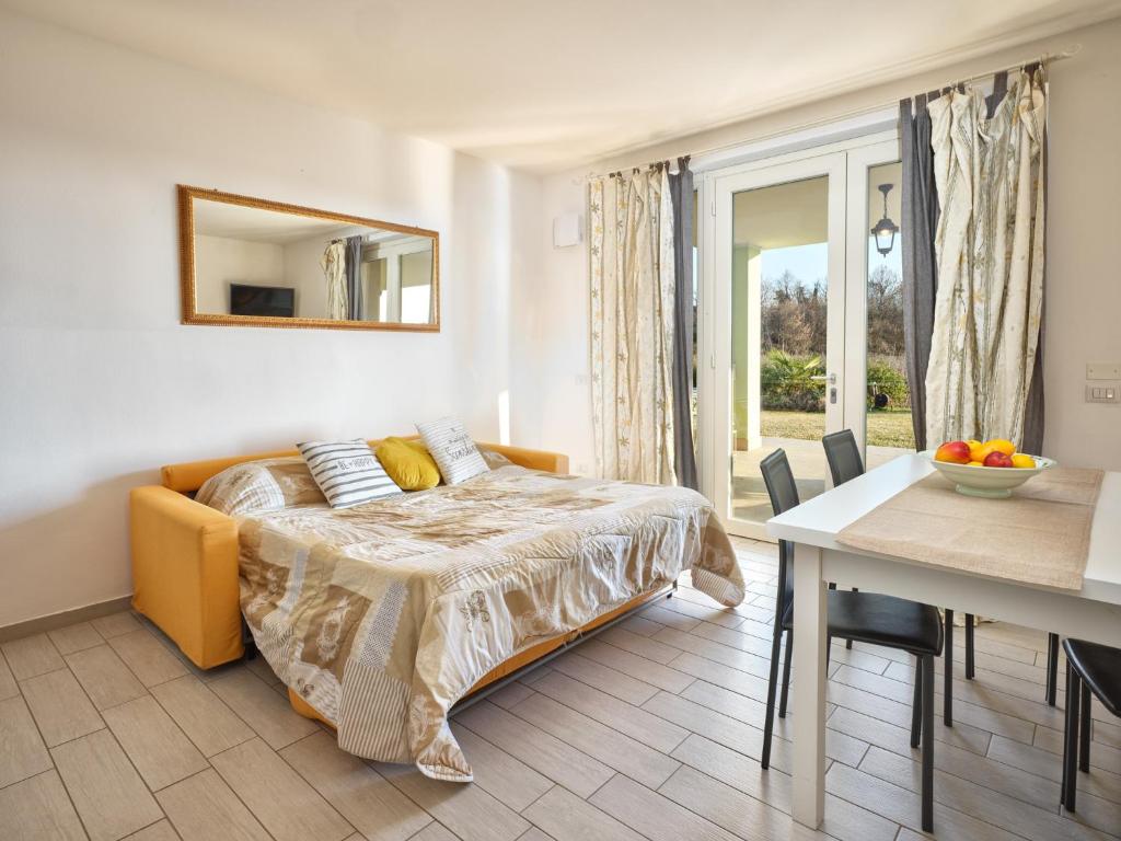 a bedroom with a bed and a dining room with a table at RESIDENZA PASTRENGO apartments - Regarda Travel in Pastrengo