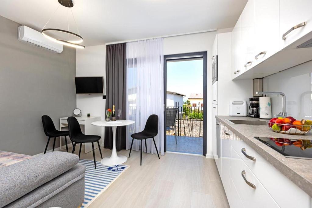 eine Küche und ein Wohnzimmer mit Tisch und Stühlen in der Unterkunft Luxury Studio Rim Tim in Malinska