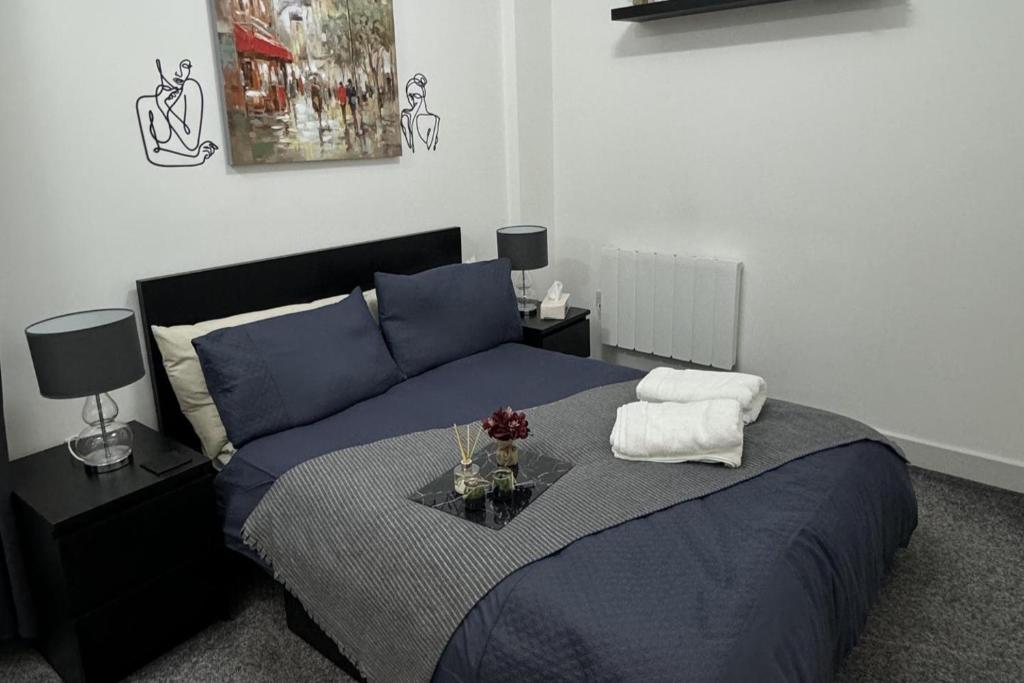 a bedroom with a blue bed with a table on it at 1 bed-Sleeps 4-Town Centre-10 min to Ascot- Pets in Bracknell