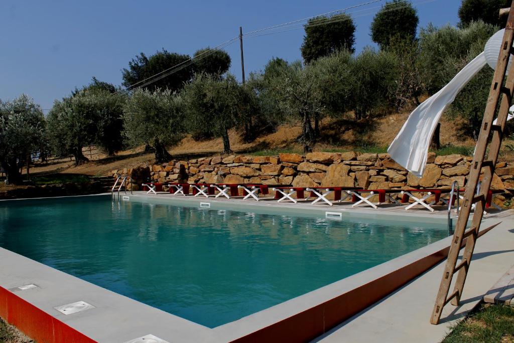a large swimming pool with a rock wall next to it at Settignano Tuscany Homes in Settignano