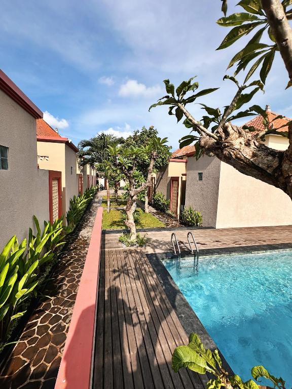 a swimming pool in front of a house at Gelis Gede Cottages in Uluwatu