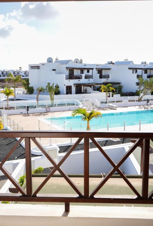 ein Blick auf den Pool vom Balkon eines Resorts in der Unterkunft CASA VELA by Mhousing in Playa Blanca