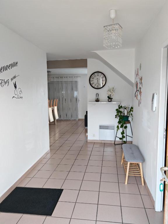 un salon avec une horloge au mur dans l'établissement Maison de campagne sur puyoo, à Puyoô