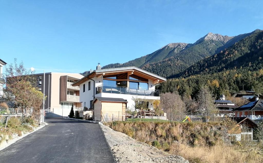 a house on the side of a road with mountains at Apartment am Mühlbach in Reith bei Seefeld