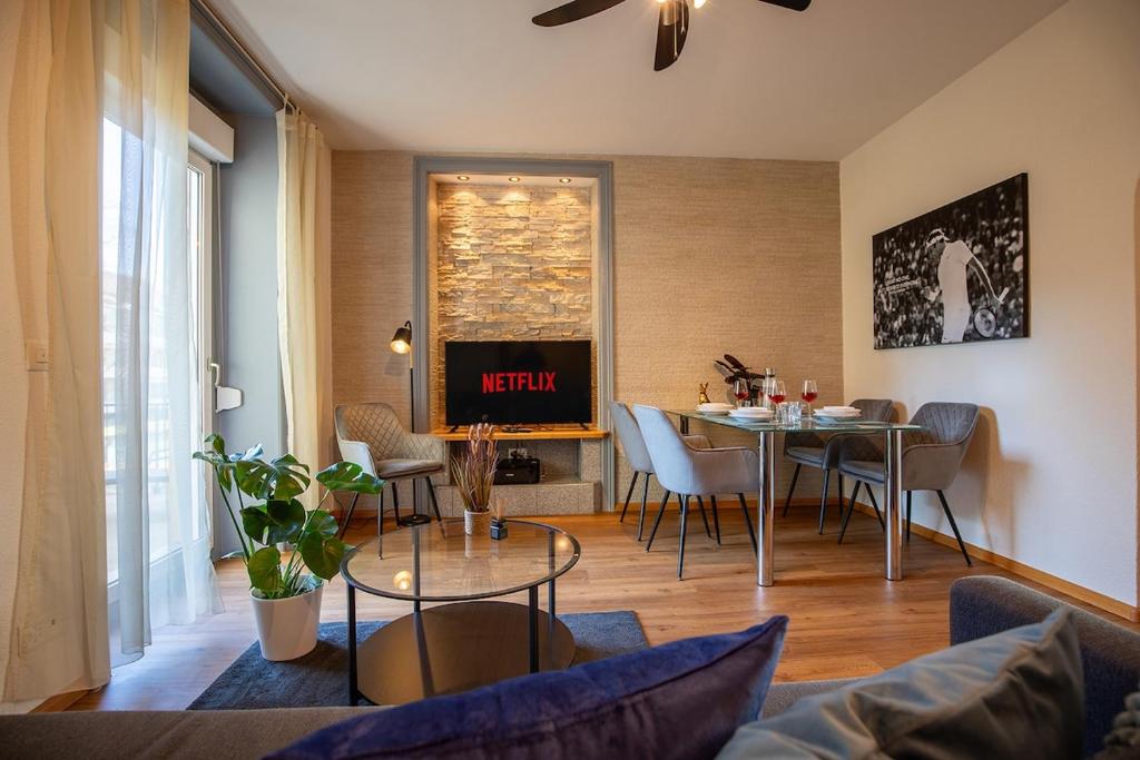 un soggiorno con tavolo e TV di Special ROGER F RABBIT 1 Apartment, Roche Towers, 10-STAR a Basilea
