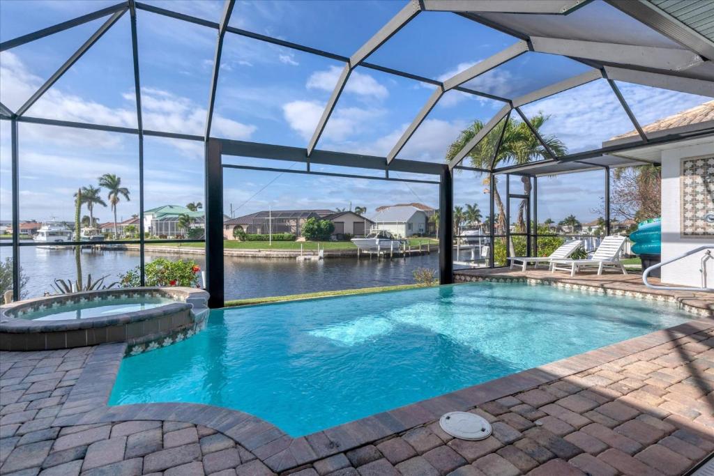 an indoor swimming pool with a large glassconservatory at SAN3337 Canalfront Vacation Pool Home in Punta Gorda