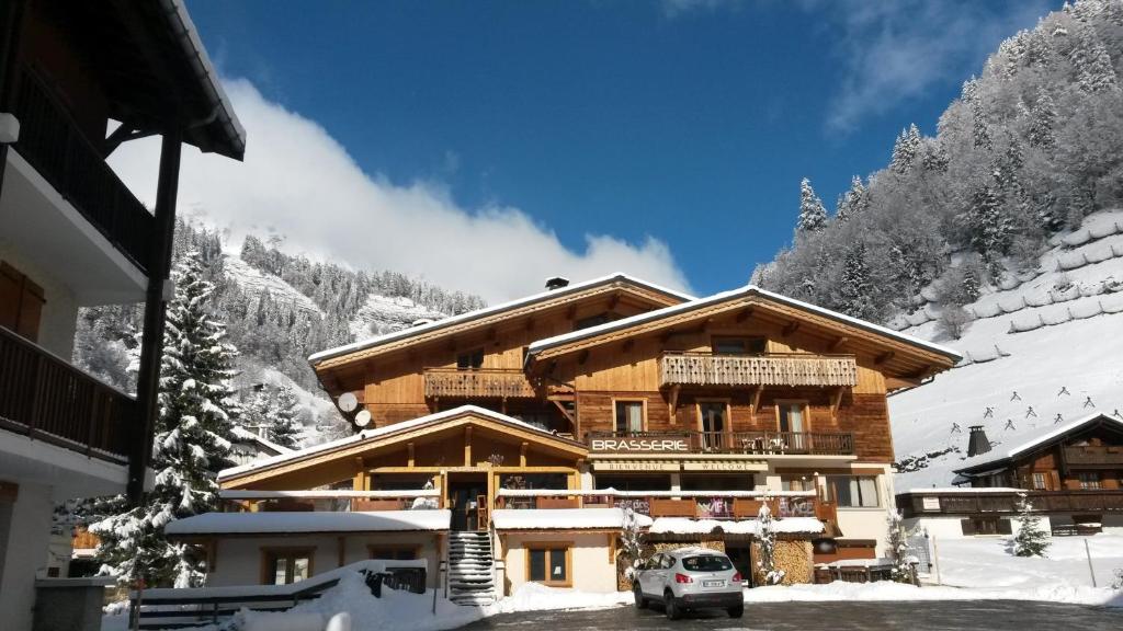 un lodge de esquí con un coche aparcado en la nieve en Apart'hotel & Spa "La Destière", en La Giettaz