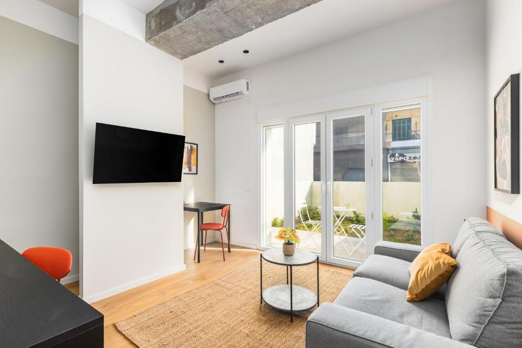 a living room with a couch and a table at Soho Residence by halu! in Thessaloniki