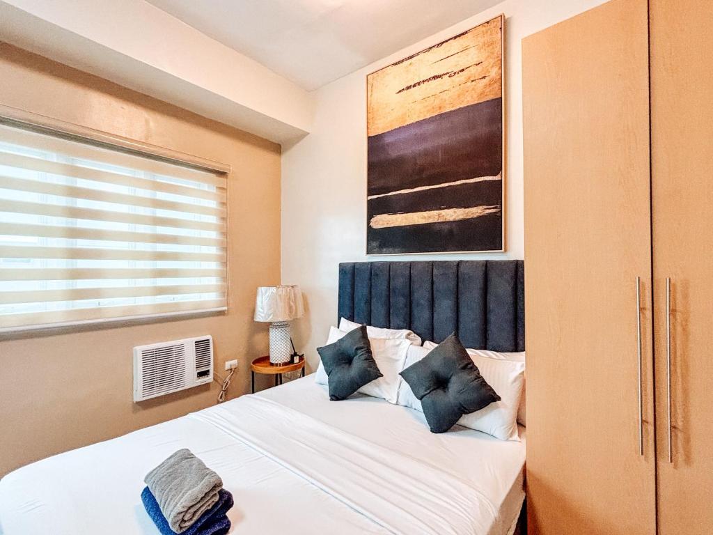 a bedroom with a bed and a window at Your Luxury Studio Escape in Iloilo City