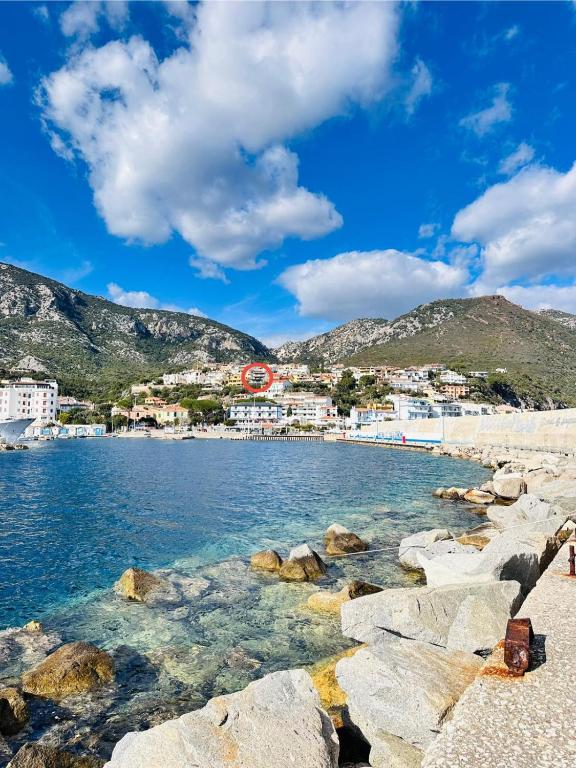 widok na plażę z kamieniami i budynkami w obiekcie Appartamento 5 Vista Panoramica w mieście Cala Gonone