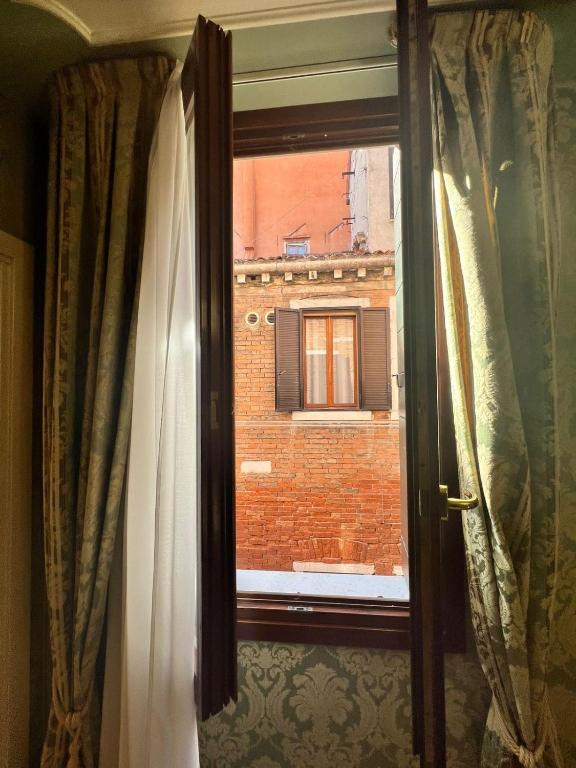 an open window with a view of a brick building at Hotel Ca' Dogaressa in Venice