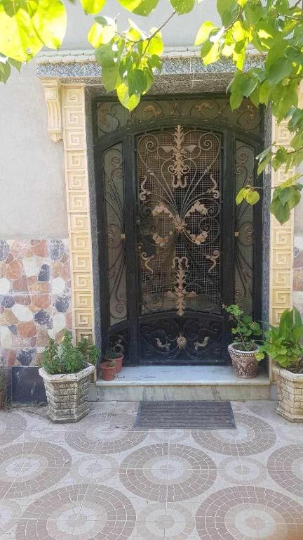 a gate with potted plants in front of a building at F2 Maison avec jardin à Constantine in Hamma Bouziane