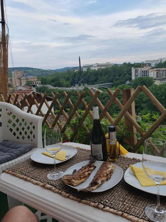 a table with two slices of pizza and a bottle of wine at Dido House Panoramic -Eurovision Fans Hub 2027 in Veliko Tŭrnovo