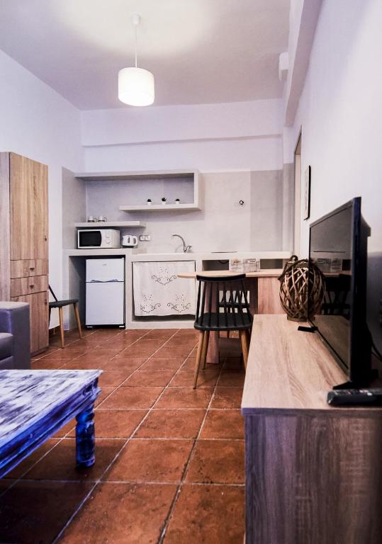 a living room with a table and a kitchen at OFIOYSA KaGa kythnosuites in Mérikhas