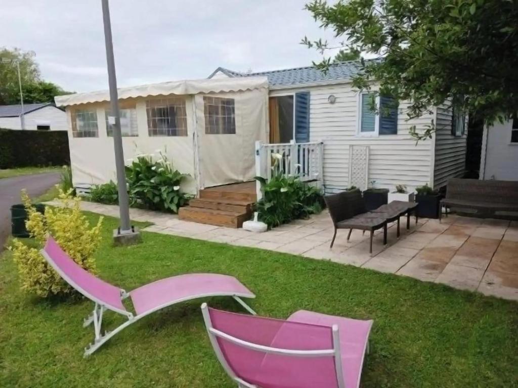 a backyard with pink chairs and a tent at Bungalow convivial à Saint-Arnoult avec piscine in Saint-Arnoult