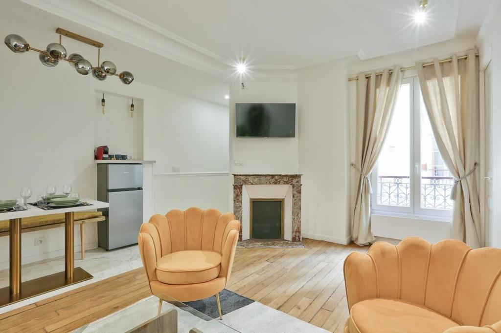 un salon avec deux chaises et une cheminée dans l'établissement Charment appartement sacrée Coeur Montmartre, à Paris