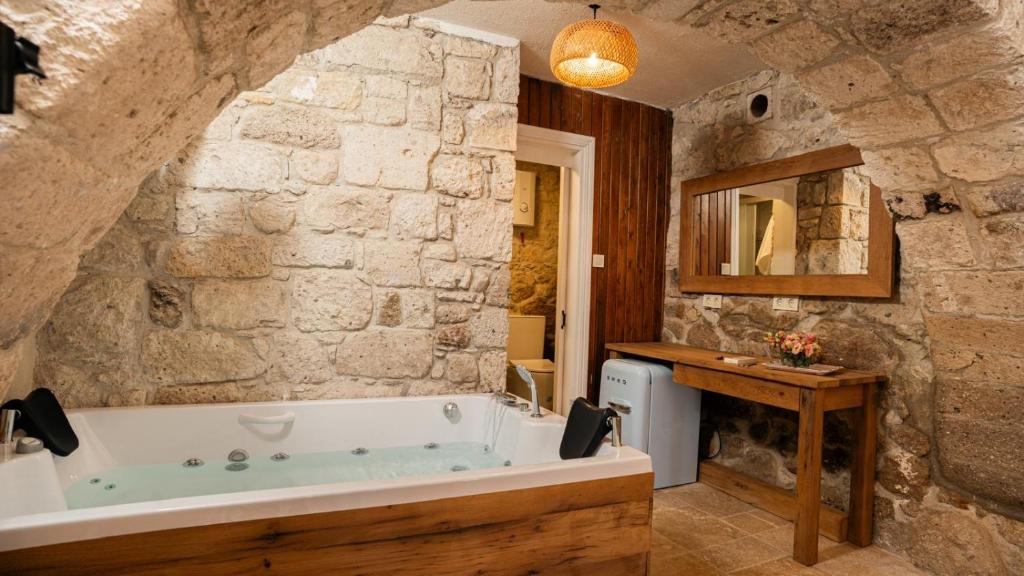 a bathroom with a bath tub in a stone wall at otel alba Alaçatı in Cesme