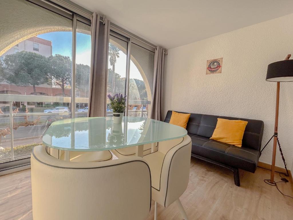 a living room with a glass table and a couch at 2 pièces apartement à Fréjus avec parking in Fréjus