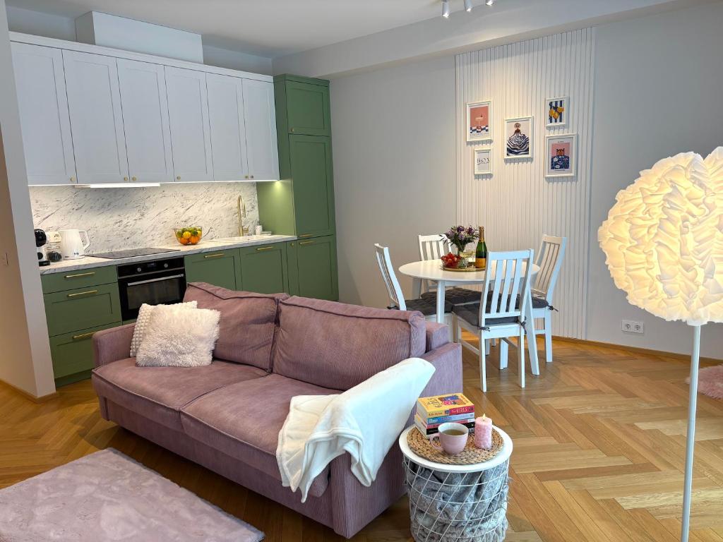 un soggiorno con divano e cucina di Tiffany Residence a Pärnu