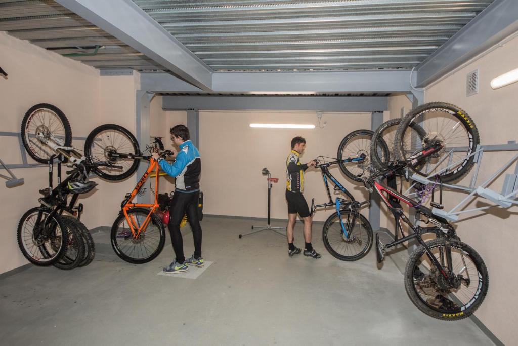 Dos hombres trabajan en bicicletas en un garaje. en Bike & Family Hotel Derby, en Finale Ligure