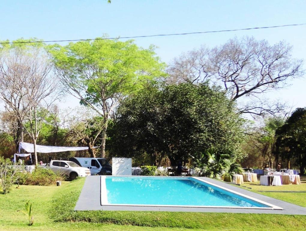 a blue swimming pool in a yard with trees at Chacara para Aluguel Recanto Eco vida Cuiaba in Cuiabá