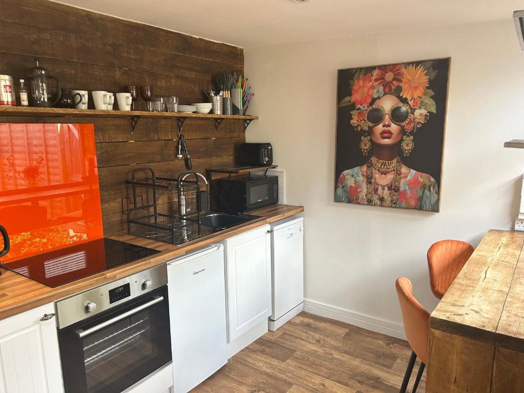 a kitchen with a black woman painting on the wall at Aiskew Villa Annex in Bedale