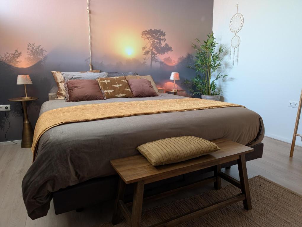 a bedroom with a large bed with a wooden table at Een Nije Dei in Arum