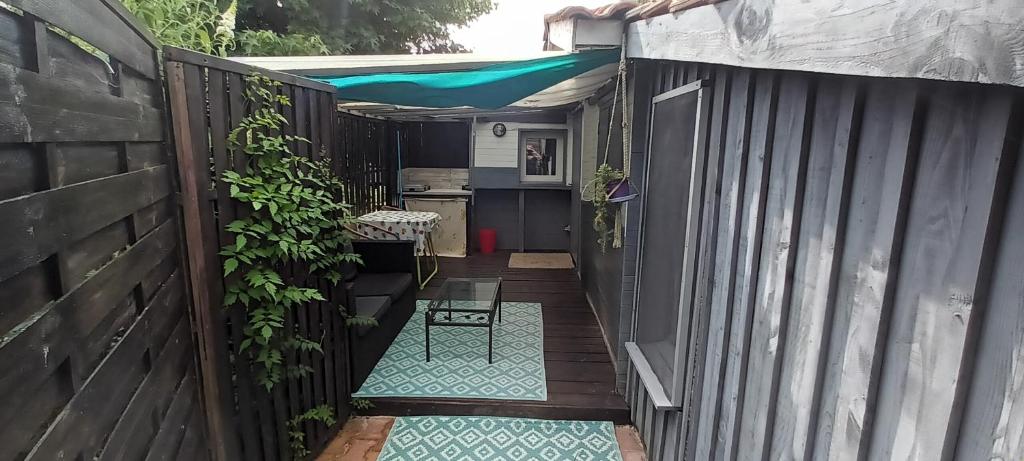 une cour avec une clôture, une table et une chaise dans l'établissement Cabane d Andernos les bains, à Andernos-les-Bains