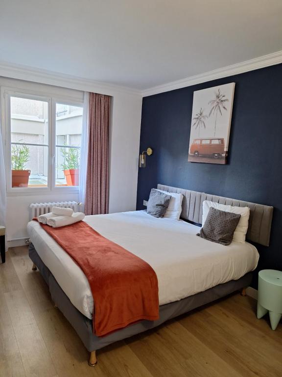 a bedroom with a large bed with blue walls at The Originals Boutique, Hôtel d'Angleterre, Le Havre, centre, plage in Le Havre