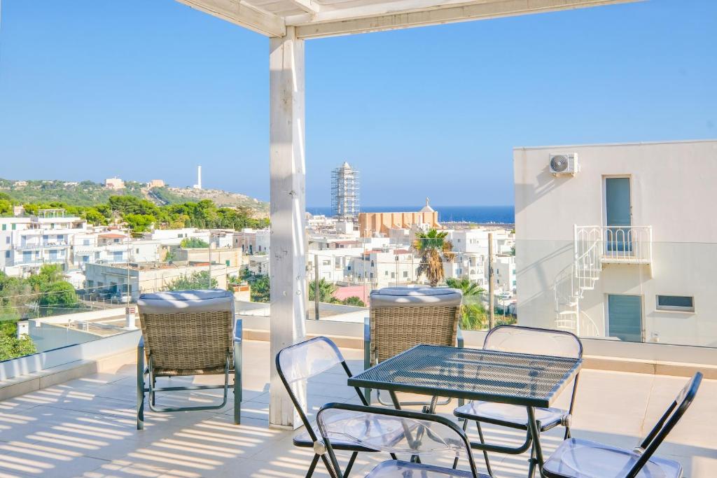 a table and chairs on a balcony with a view of the city at Le Cammire Luxury Apartment - Leuca in Leuca