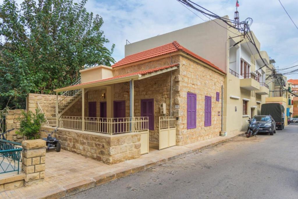 贝鲁特Standalone 1-BR Apt with Terrace in Ashrafieh的街上带紫色窗户的砖房
