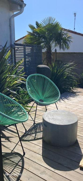 two green chairs and a table on a deck at Nanouchka in Médis