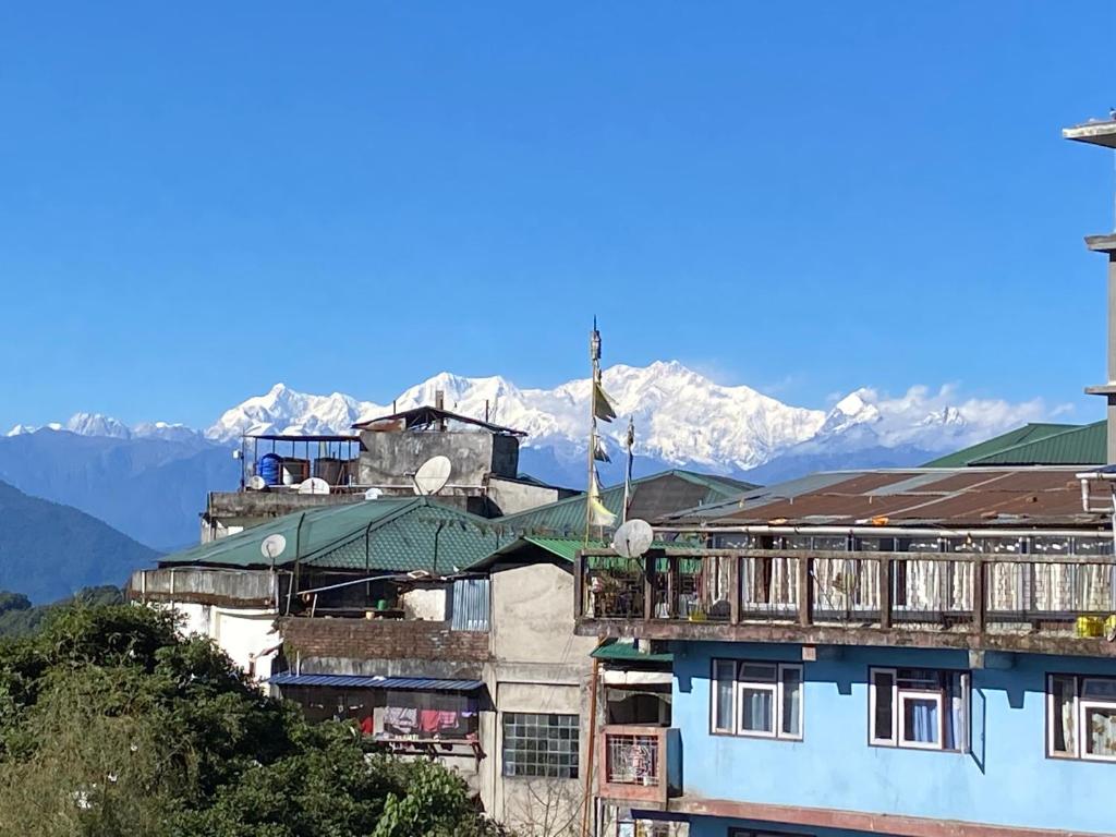 ein Gebäude mit einem Balkon und Bergen im Hintergrund in der Unterkunft VINTAGE HOMES, Darjeeling in Darjeeling