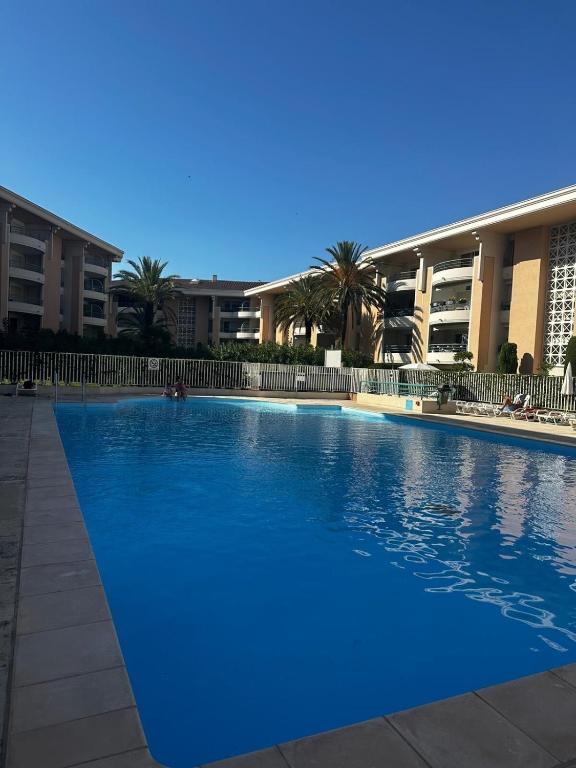 une grande piscine bleue devant un immeuble dans l'établissement Fréjus 2 pièces avec Terrasse, proche des Plages, à Fréjus
