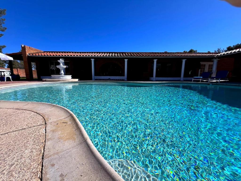 Una gran piscina azul frente a una casa en Casa de Anza, en Tubac Ultralight Flightpark