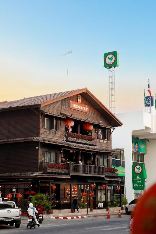 a building on a street with people on a motorcycle at Pukha Nanfa Hotel in Nan