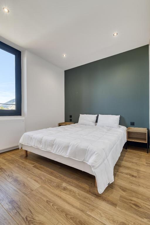 Cette chambre comprend un grand lit blanc et une grande fenêtre. dans l'établissement La Cosyne - chambre en colocation, à Collonges-sous-Salève