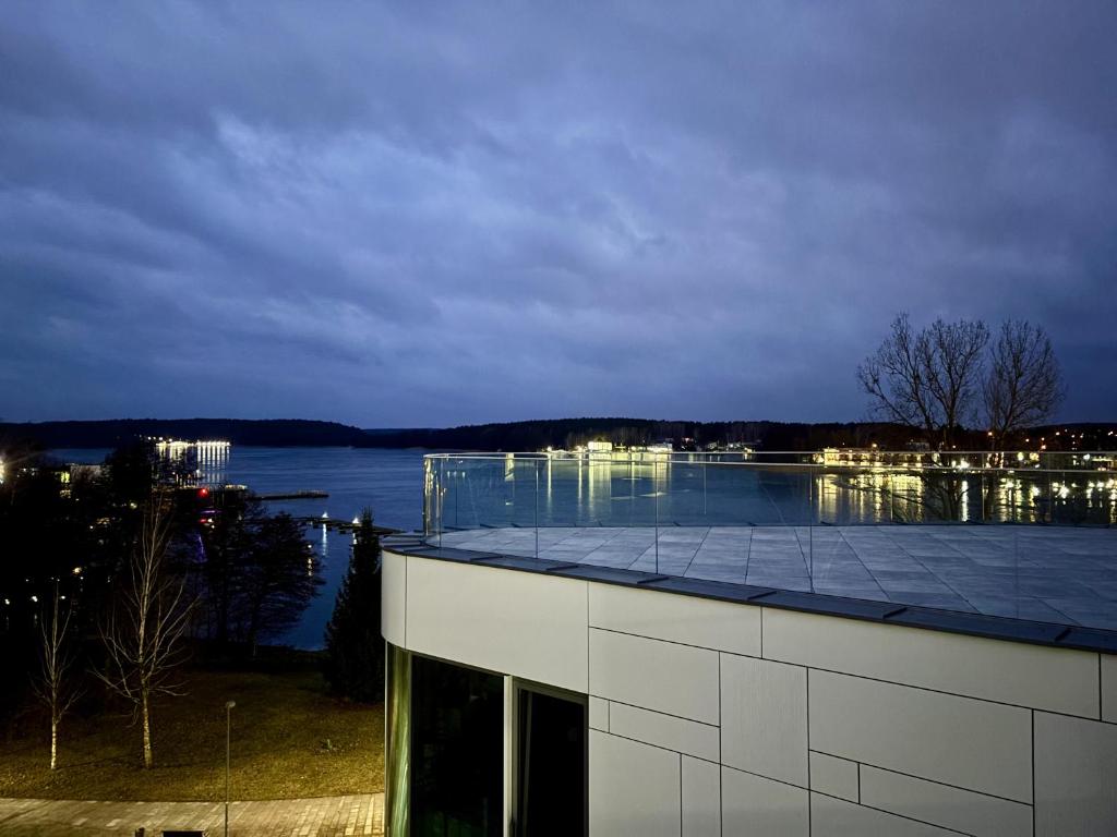 オルシュティンにあるApartament Premium nad jeziorem, przy samej plaży miejskiejの水面の見える建物の屋根