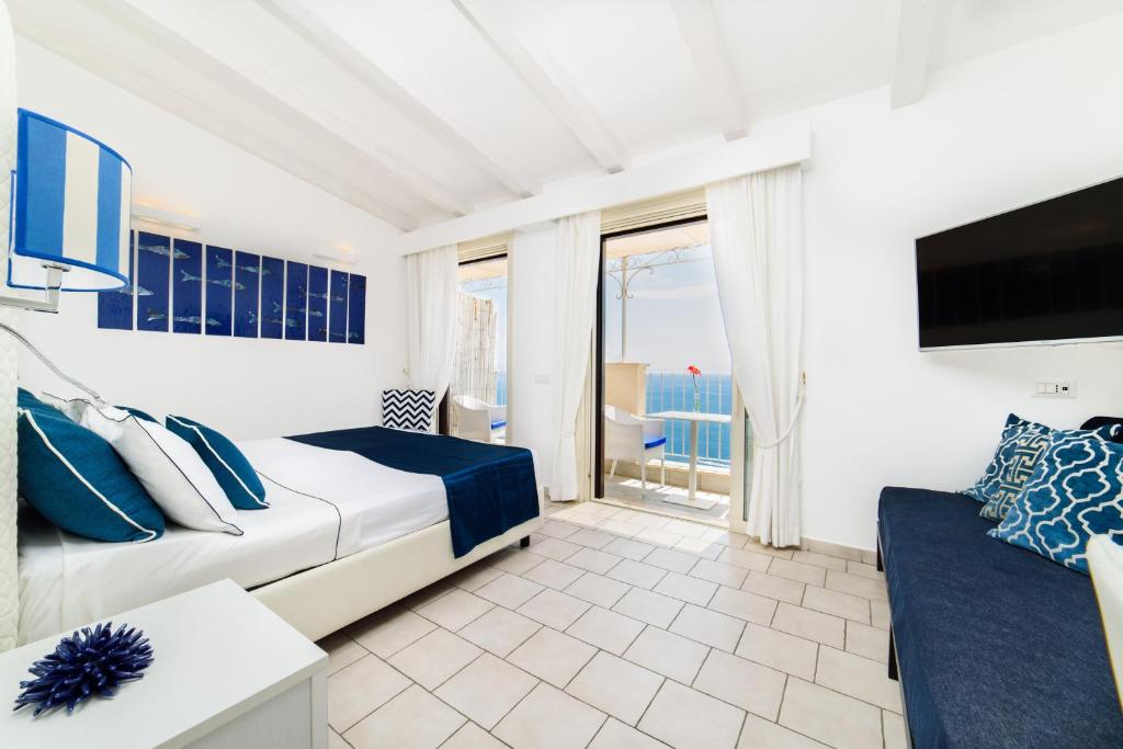 una camera da letto con un letto, una TV e un divano di Residenza Al Pesce D'Oro ad Amalfi