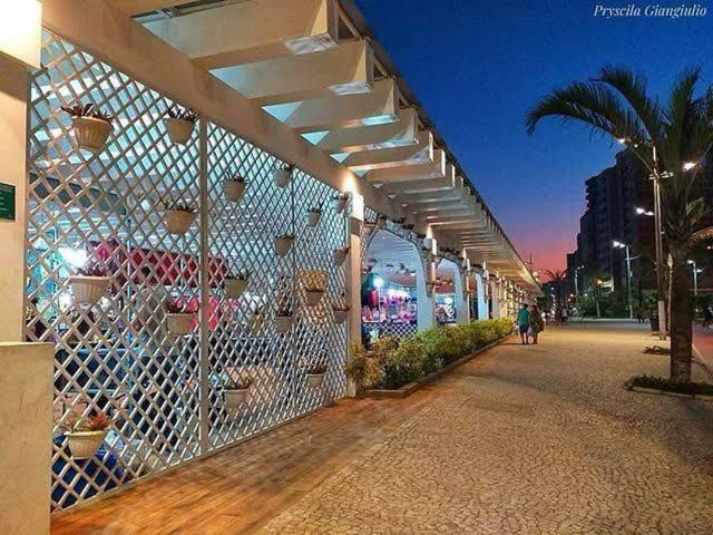 大普拉亚apartamento praia grande sp的一栋有围栏的建筑物和一名在街上行走的人