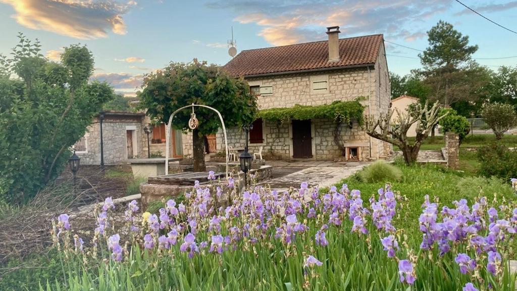 une maison avec des fleurs violettes devant dans l'établissement La Maison du Carrier, à Ruoms