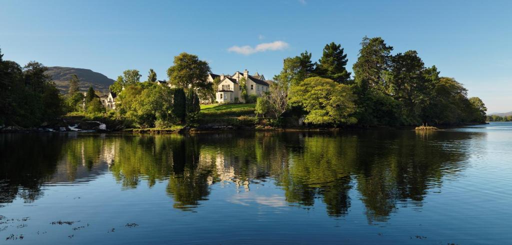 
a lake with a house and some trees at Sheen Falls Lodge in Kenmare
