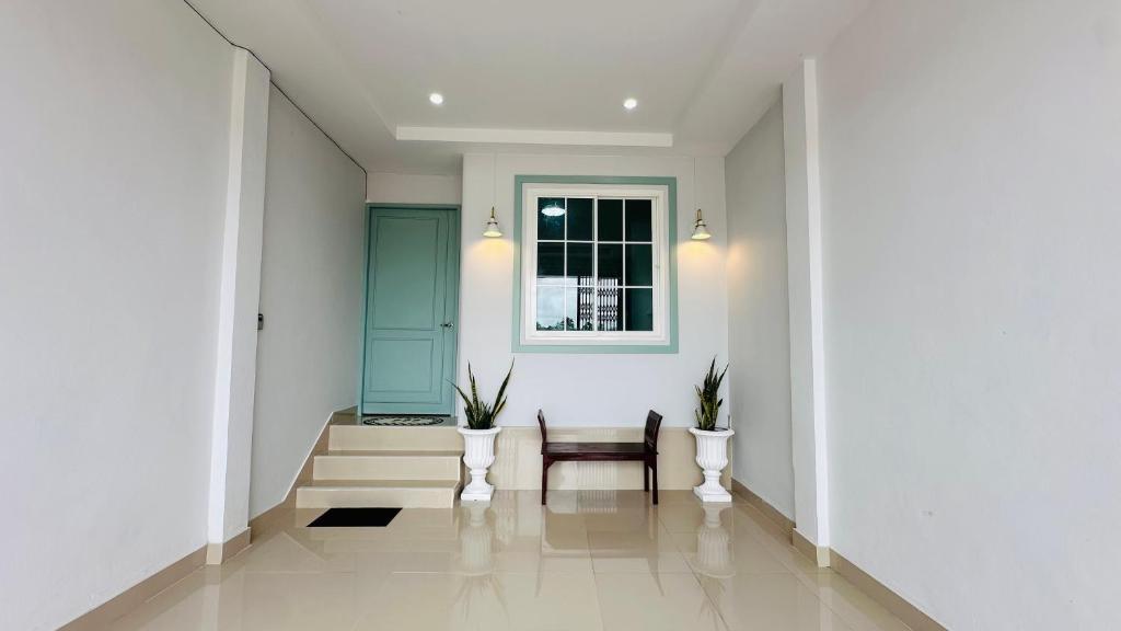 a hallway with a chair and a window at Hatyai riverfront nest in Hat Yai